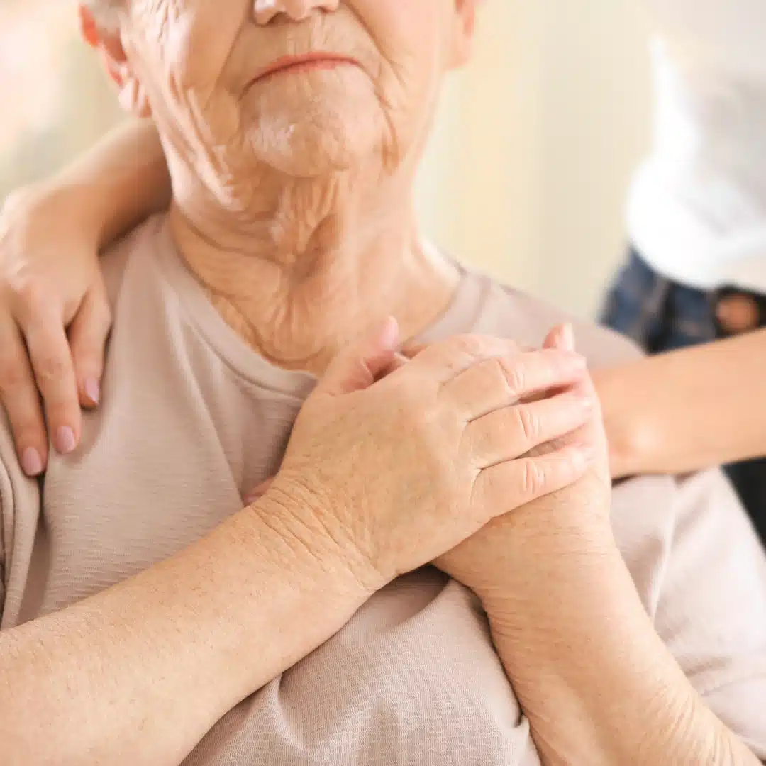 woman holding her family's hand over her shoulder discussing end of life plannning